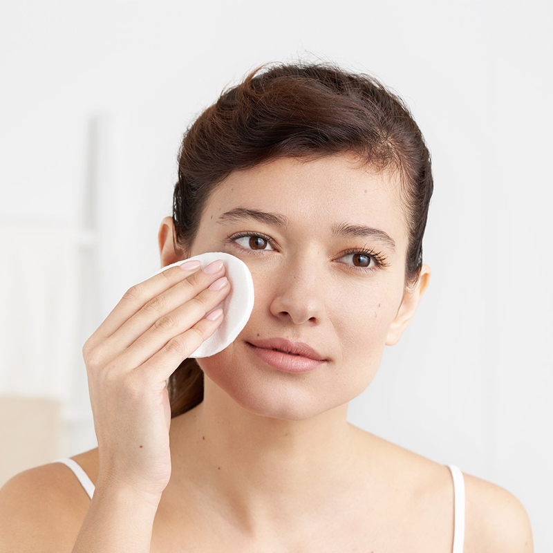 woman cleaning her face with a cotton